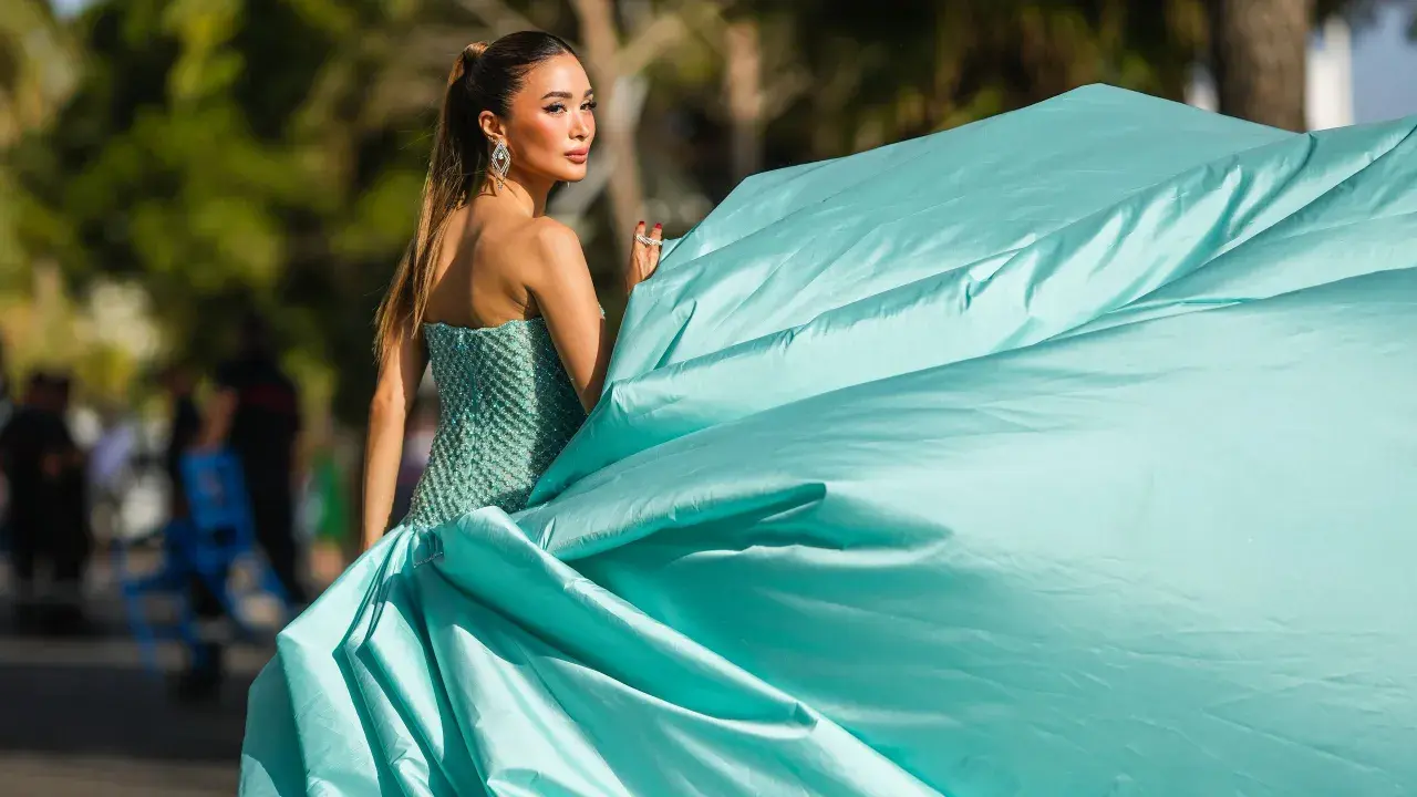 Elegante Frau in einem mintgrünen, bestickten Kleid mit weitem Rock, bereit für einen Anlass, bei dem "black tie optional" gilt.