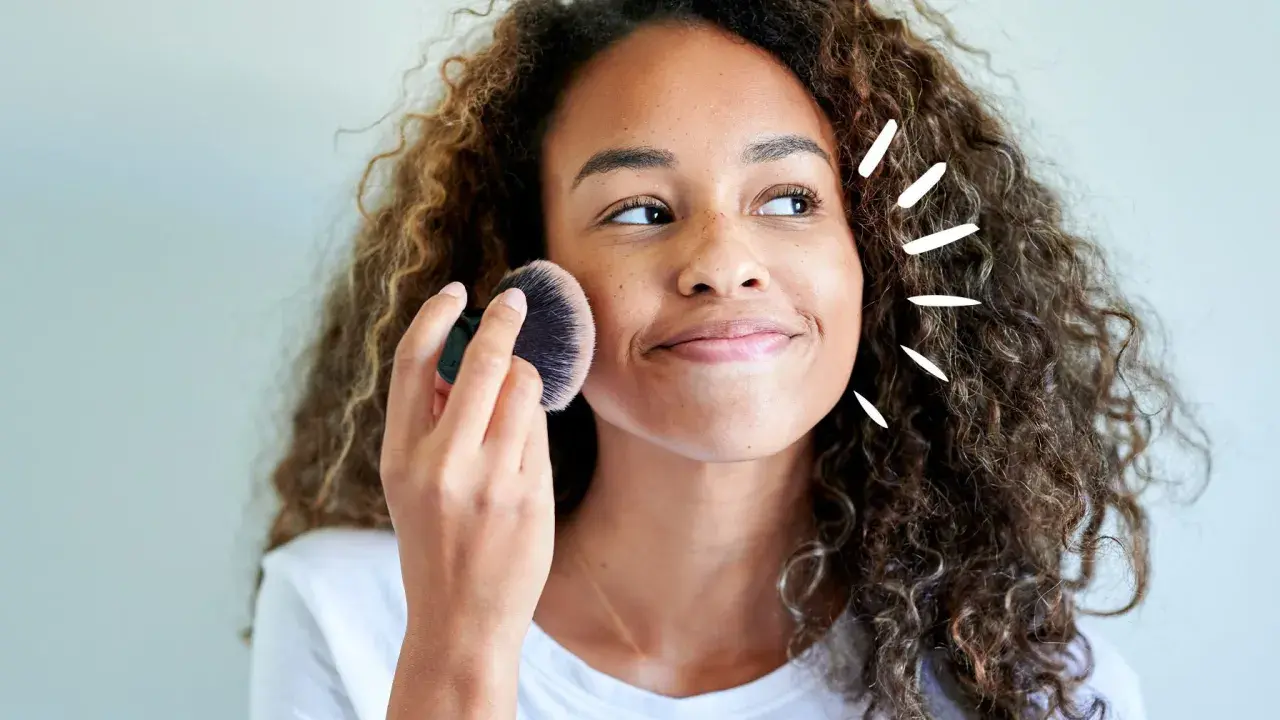 Frau mit Locken trägt Puder auf. Vorsicht, trocknet Babypuder die Haut aus?