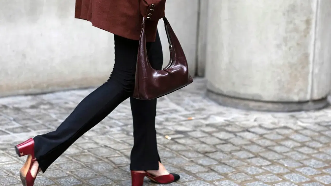 Schwarze Stoffhose kombinieren: Ein schicker Look mit brauner Tasche und zweifarbigen Slingback-Schuhen.
