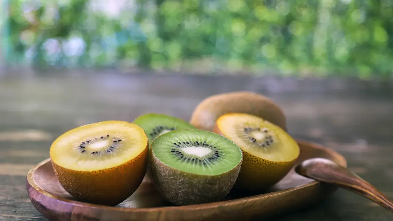 Süße Kiwis, grün und gelb, auf einem Holztablett. Sie sind so gesund und lecker!