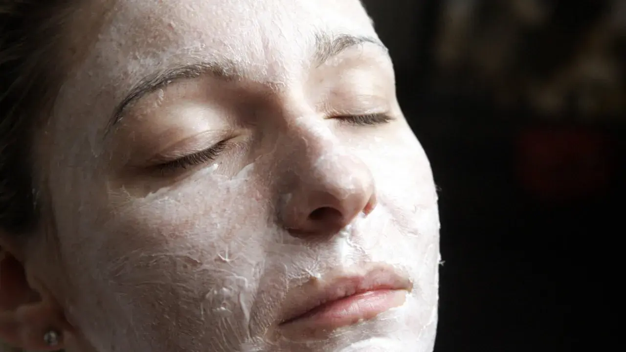 Nahaufnahme einer Frau mit geschlossenen Augen, die eine Quark Honig-Maske gegen Falten trägt.