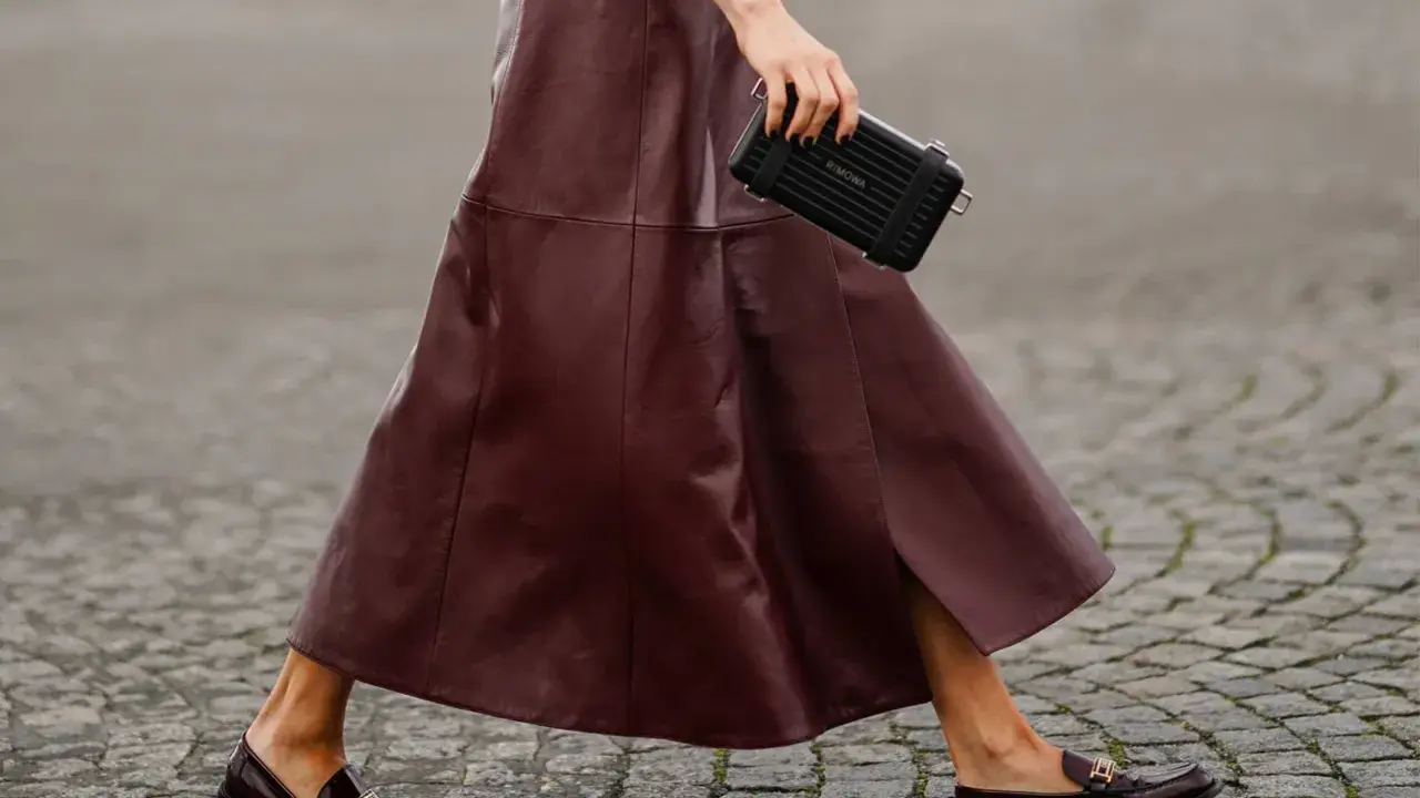 Schicke flache Schuhe zum Kleid: Dunkelrote Leder-Loafer mit goldenen Schnallen und ein passender Rock.