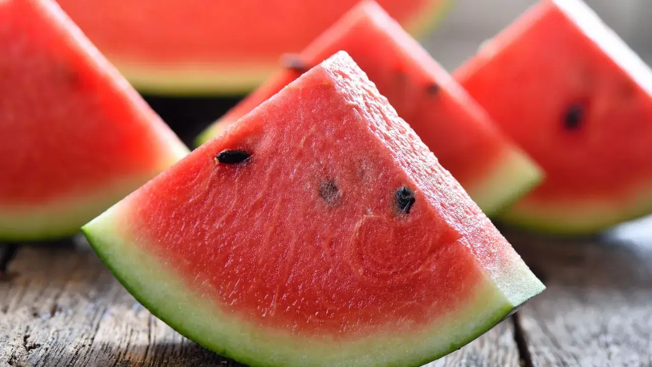 Saftige Wassermelonenstücke auf Holz. Perfekt, um sie abends zu essen und die Süße zu genießen.