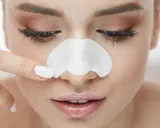 Frau wendet eine Nasenmaske an, um Mitesser auf der Nase zu entfernen.