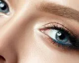 Nahaufnahme eines blauen Auges mit aufwendigem Augen-Make-up, das zeigt, wie man Augenlider schminkt.