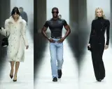 Models präsentieren auf dem Laufsteg Looks von Gucci Designer: eine Frau im Pelzmantel, ein Mann in Jeans und ein Model in einem glitzernden schwarzen Kleid.