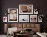 Ein Wohnzimmer mit brauner Ledercouch, Kunstwerken in Erdtönen und einem schwarzen Lampenschirm. Diese Farben passen gut zu Schwarz und schaffen eine elegante Atmosphäre.