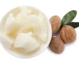 Schüssel mit weißer Sheabutter, dane drei Nüsse und zwei grüne Blätter. Manche empfinden Sheabutter als komedogen.