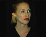 Frau mit blondem Pferdeschwanz und rotem Lippenstift, im **Carolyn Bessette-Kennedy Style**, blickt nach rechts.