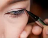 Präzises **eyeliner ziehen bei schlupflidern** mit einem Eyeliner-Stift. Ein feiner Lidstrich hebt das Auge hervor.