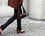 Schwarze Stoffhose kombinieren: Ein schicker Look mit brauner Tasche und zweifarbigen Slingback-Schuhen.