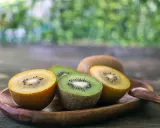 Süße Kiwis, grün und gelb, auf einem Holztablett. Sie sind so gesund und lecker!