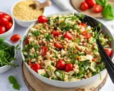 Ein bunter Nudelsalat mit Kirschtomaten, Rucola und Pinienkernen – perfekt für gesunde Sommerrezepte.