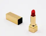Ein roter Lippenstift in goldenem Etui, bereit für den perfekten Auftritt. Die Frage nach der Lippenstift Haltbarkeit ist hier nebensächlich, denn dieser Luxus ist zeitlos.