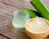 Frische Aloe Vera Blätter, Gel und Stücke in einer Holzschale, bereit für Aloe Vera Rezepte Kosmetik.
