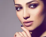Ein Porträt einer Frau mit **smokey eyes dezent**. Ihre Augen sind von einem sanften, rauchigen Lidschatten umrahmt, der ihre braunen Augen betont.