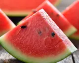 Saftige Wassermelonenstücke auf Holz. Perfekt, um sie abends zu essen und die Süße zu genießen.