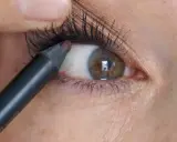 Ein Kajalstift wird auf die untere Wasserlinie des Auges aufgetragen, um den Blick zu intensivieren.