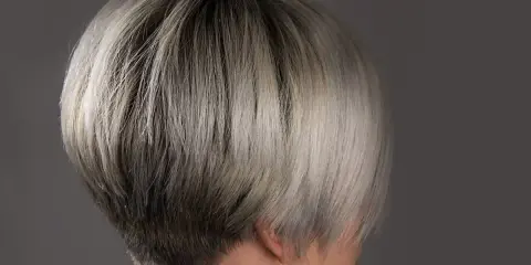 Ein moderner, kurzer Bob mit sehr feinem Haar, das von dunkel zu hellblond verläuft.