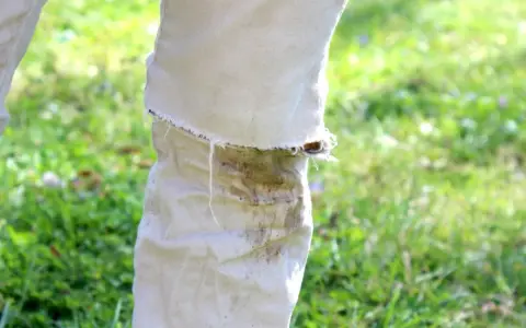 Hose mit hartnäckigen Grasflecken, die nach einer Wäsche noch sichtbar sind. Tipps zum Grasflecken entfernen gesucht.