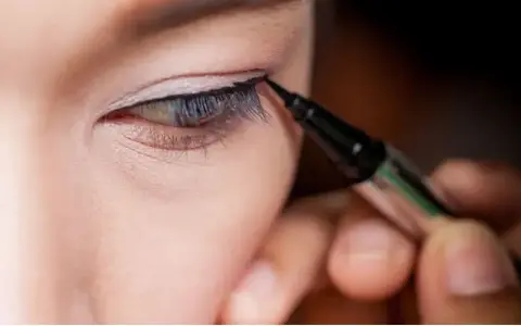 Präzises **eyeliner ziehen bei schlupflidern** mit einem Eyeliner-Stift. Ein feiner Lidstrich hebt das Auge hervor.