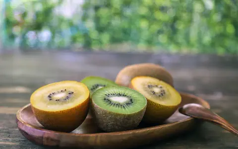 Süße Kiwis, grün und gelb, auf einem Holztablett. Sie sind so gesund und lecker!
