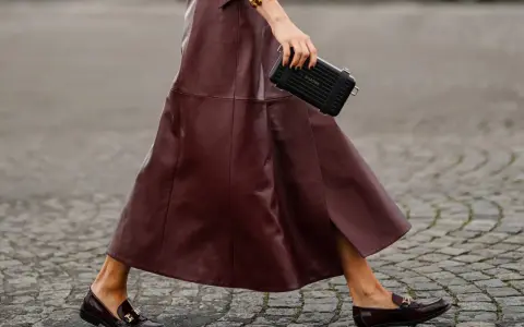 Schicke flache Schuhe zum Kleid: Dunkelrote Leder-Loafer mit goldenen Schnallen und ein passender Rock.