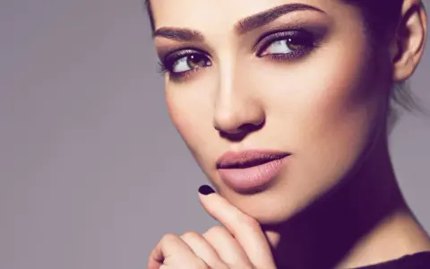 Ein Porträt einer Frau mit **smokey eyes dezent**. Ihre Augen sind von einem sanften, rauchigen Lidschatten umrahmt, der ihre braunen Augen betont.
