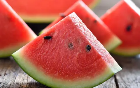 Saftige Wassermelonenstücke auf Holz. Perfekt, um sie abends zu essen und die Süße zu genießen.