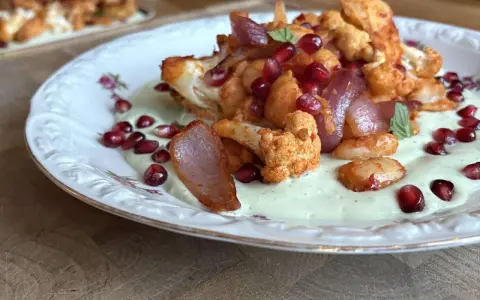 Gerösteter Blumenkohl mit Granatapfelkernen und cremiger Sauce – ein leichtes Essen für den Sommer.