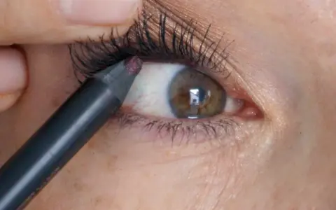 Ein Kajalstift wird auf die untere Wasserlinie des Auges aufgetragen, um den Blick zu intensivieren.