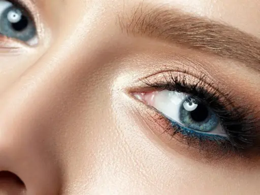 Nahaufnahme eines blauen Auges mit aufwendigem Augen-Make-up, das zeigt, wie man Augenlider schminkt.