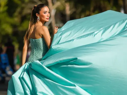 Elegante Frau in einem mintgrünen, bestickten Kleid mit weitem Rock, bereit für einen Anlass, bei dem "black tie optional" gilt.