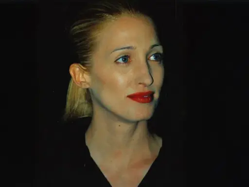 Frau mit blondem Pferdeschwanz und rotem Lippenstift, im **Carolyn Bessette-Kennedy Style**, blickt nach rechts.