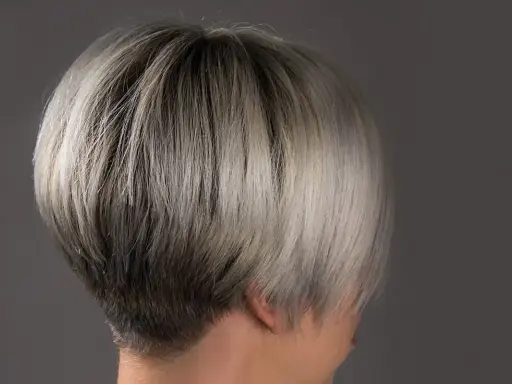 Ein moderner, kurzer Bob mit sehr feinem Haar, das von dunkel zu hellblond verläuft.