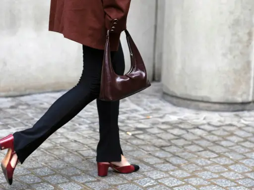 Schwarze Stoffhose kombinieren: Ein schicker Look mit brauner Tasche und zweifarbigen Slingback-Schuhen.