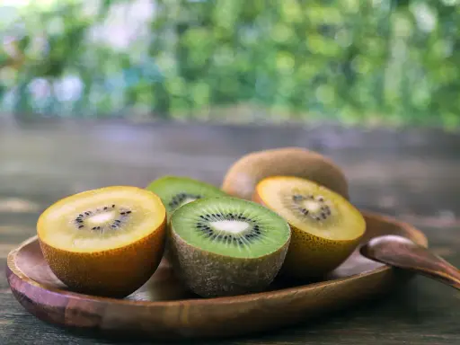 Süße Kiwis, grün und gelb, auf einem Holztablett. Sie sind so gesund und lecker!