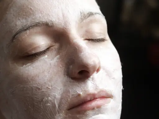 Nahaufnahme einer Frau mit geschlossenen Augen, die eine Quark Honig-Maske gegen Falten trägt.