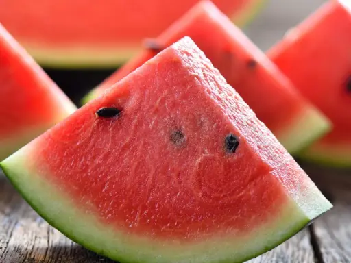Saftige Wassermelonenstücke auf Holz. Perfekt, um sie abends zu essen und die Süße zu genießen.