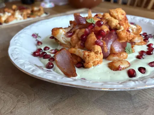 Gerösteter Blumenkohl mit Granatapfelkernen und cremiger Sauce – ein leichtes Essen für den Sommer.