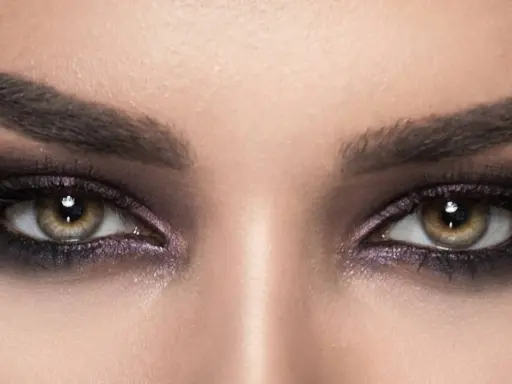 Nahaufnahme von Augen mit **stark geschminkten Augen**, dunklem Lidschatten und langen Wimpern.