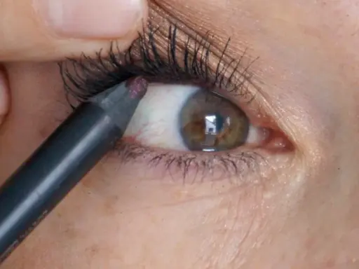 Ein Kajalstift wird auf die untere Wasserlinie des Auges aufgetragen, um den Blick zu intensivieren.