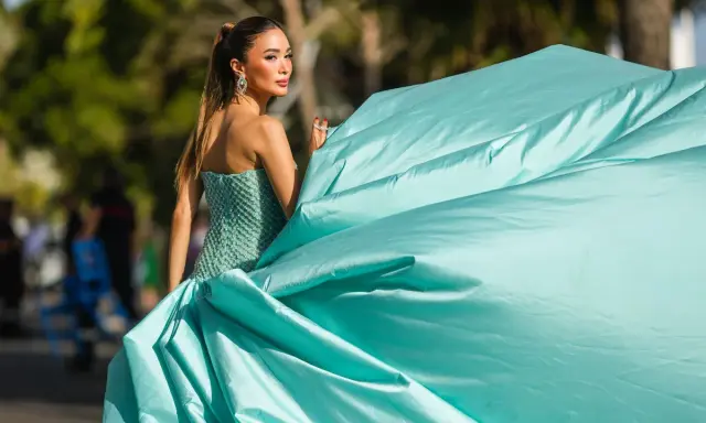 Elegante Frau in einem mintgrünen, bestickten Kleid mit weitem Rock, bereit für einen Anlass, bei dem "black tie optional" gilt.