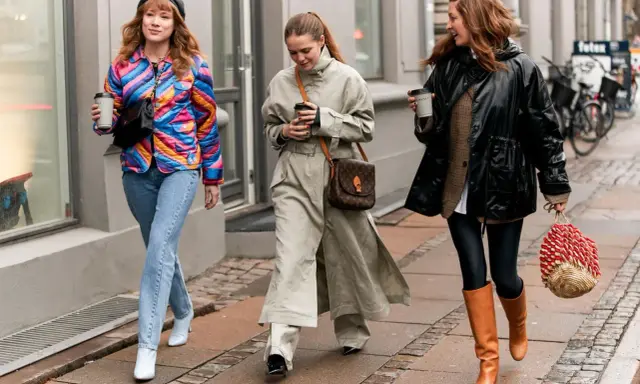 Drei Frauen spazieren mit Kaffee. Die mittlere trägt weite Hosen zu Pumps. Die rechte zeigt, welche Hose zu Boots Damen passt: Leggings und hohe Stiefel.