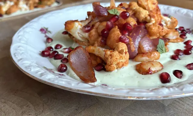 Gerösteter Blumenkohl mit Granatapfelkernen und cremiger Sauce – ein leichtes Essen für den Sommer.