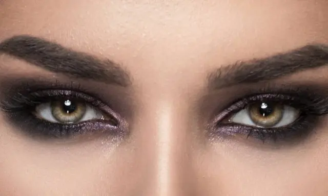 Nahaufnahme von Augen mit **stark geschminkten Augen**, dunklem Lidschatten und langen Wimpern.