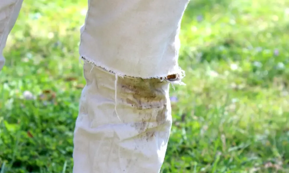 Hose mit hartnäckigen Grasflecken, die nach einer Wäsche noch sichtbar sind. Tipps zum Grasflecken entfernen gesucht.