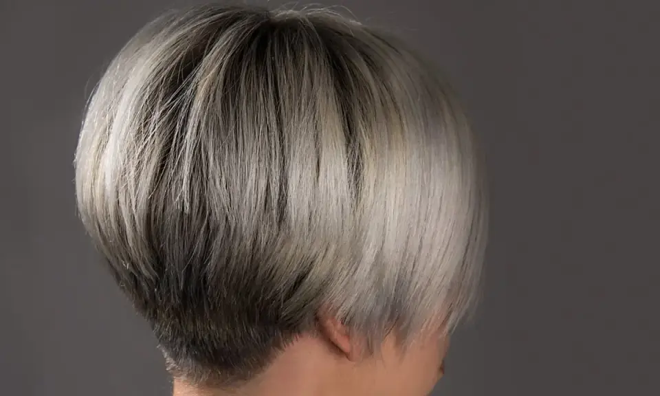 Ein moderner, kurzer Bob mit sehr feinem Haar, das von dunkel zu hellblond verläuft.