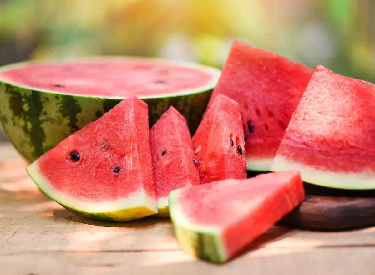 Saftige Wassermelonenst&uuml;cke liegen auf Holz. Die Wassermelone Heilkraft zeigt sich in ihrer erfrischenden S&uuml;&szlig;e und vielen Vitaminen.