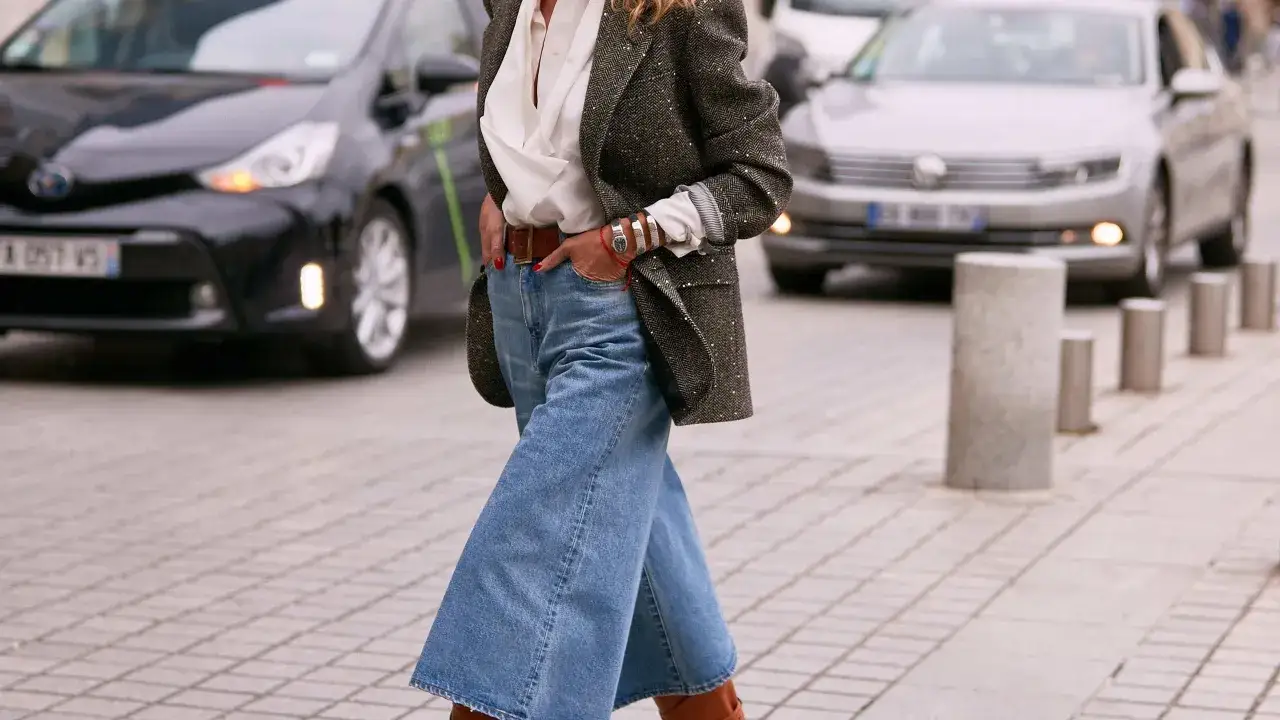 Stylische Frau in culotte jeans, weißer Bluse und Tweed-Blazer. So kann man culotte jeans kombinieren für einen lässigen City-Look.